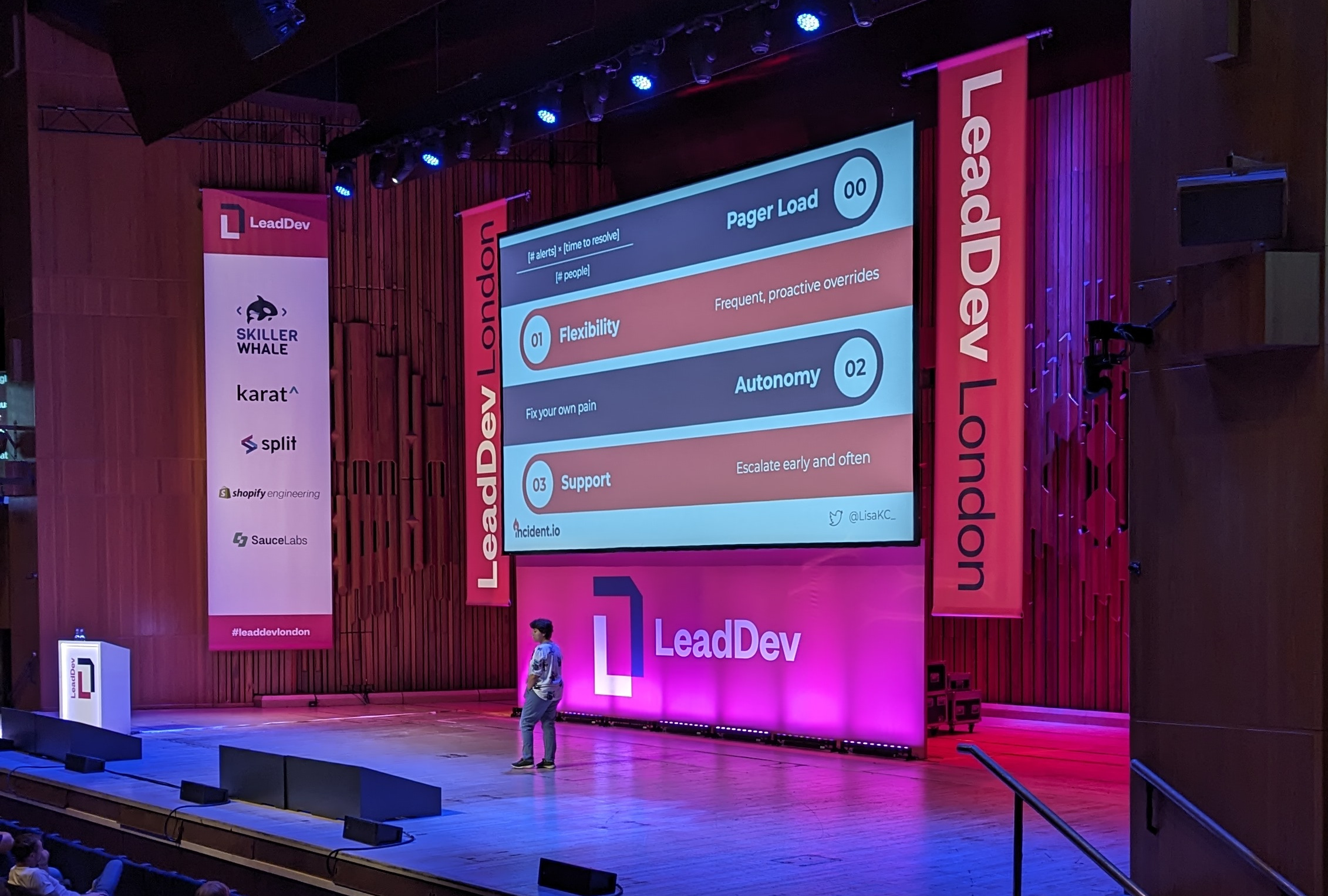 Lisa standing on the stage at LeadDev London, with the slide behind her showing four key areas to work on to make on-call nicer. First, Pager Load to ensure that there aren't too many alerts for the number of people on the rota. Secondly, Flexibility, to allow for frequent, proactive overrides. Third, teams need Autonomy to allow them to fix their own pain points. And finally, Support, to allow engineers to escalate early and often