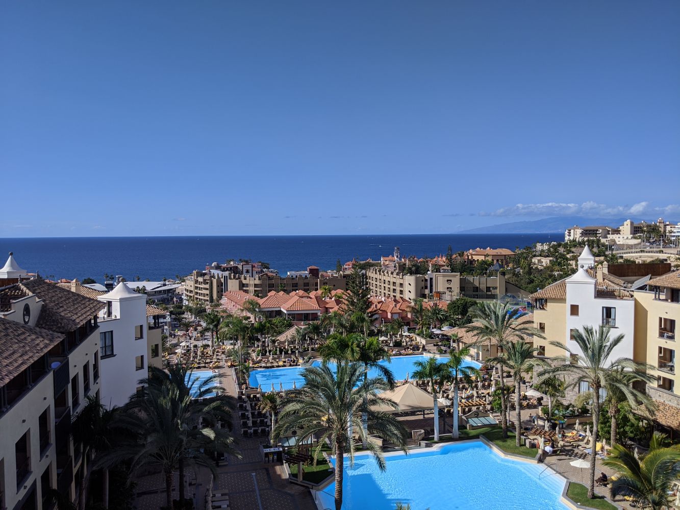 Blue sky with limited clouds, looking over the pool and sea Blue sky with limited clouds, looking over the pool and sea