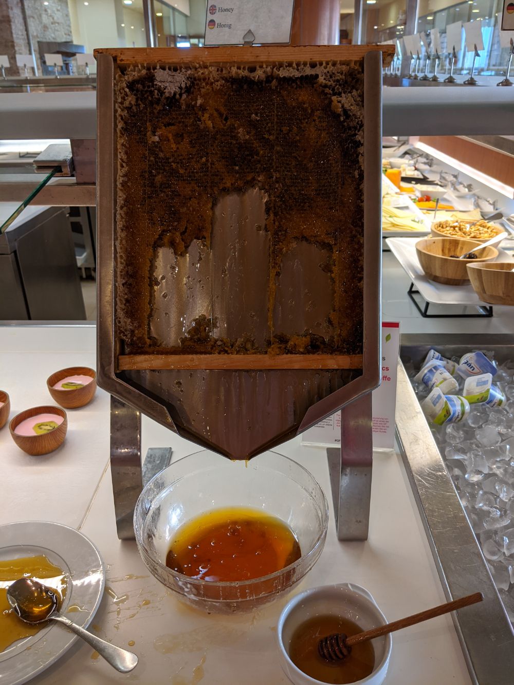 A wooden container containing honeycomb, allowing guests to scrape the honey + honeycomb out